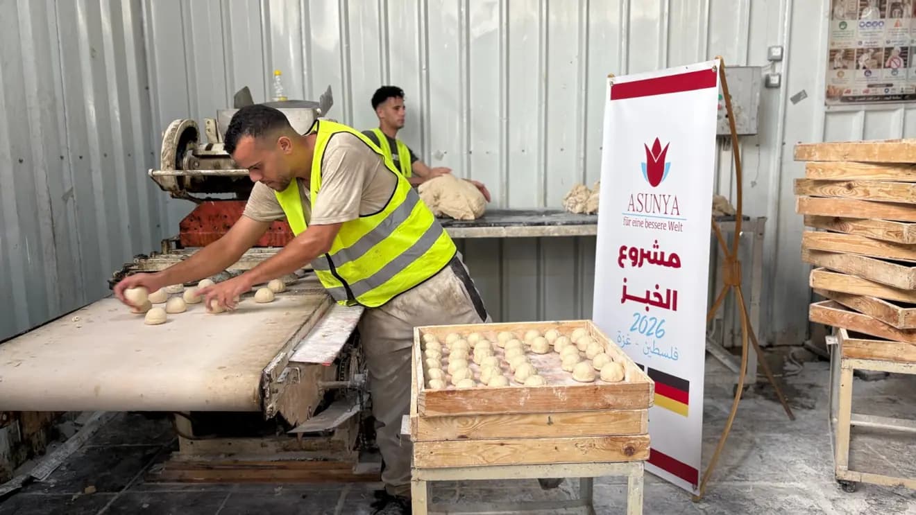 Ein Helfer in Warnweste formt Teig an einer Brotmaschine, daneben ein Banner von Asunya zum Brotprojekt 2026 in Gaza.