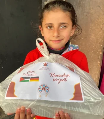 Ein Mäschen hält ein Iftarpaket von Ramadan 2025